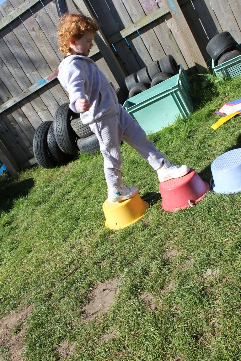 A child stepping across coloured stepping stones