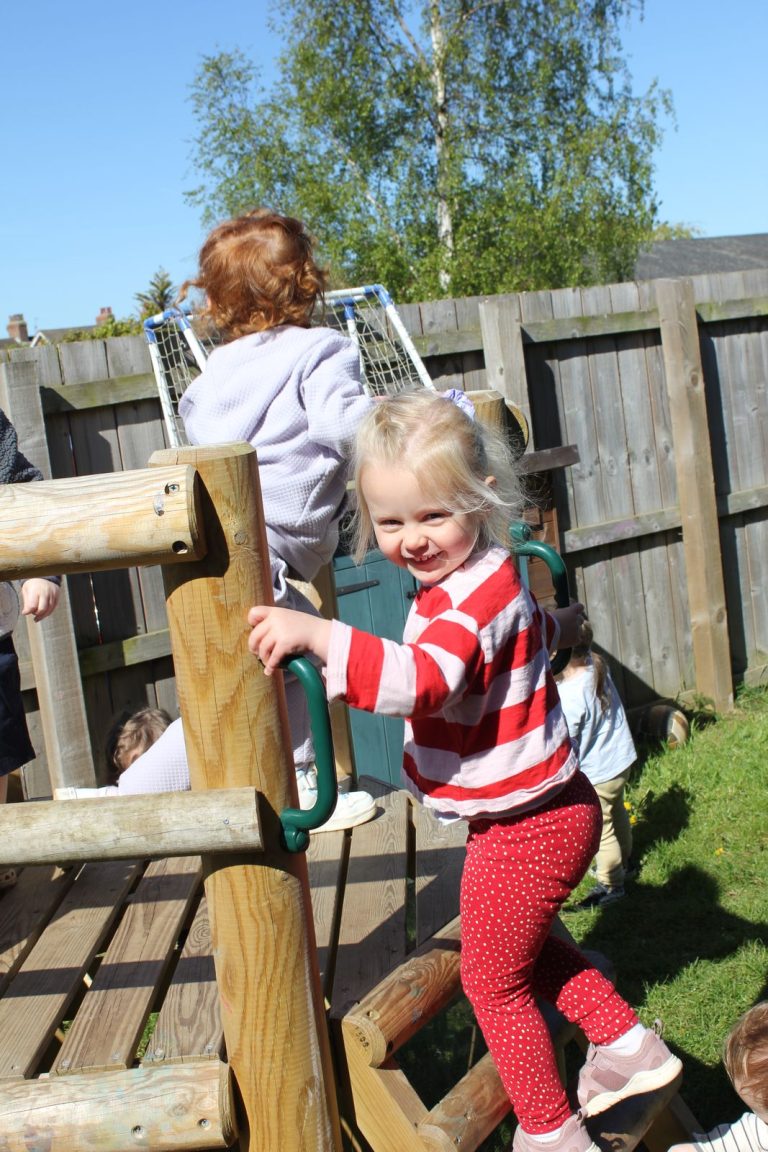 A child climbing on the wooden play equipment