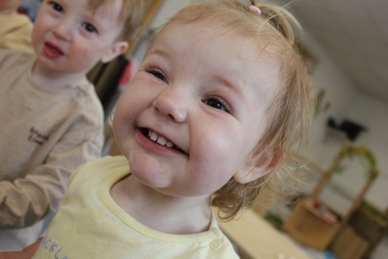 A baby grinning at the camera